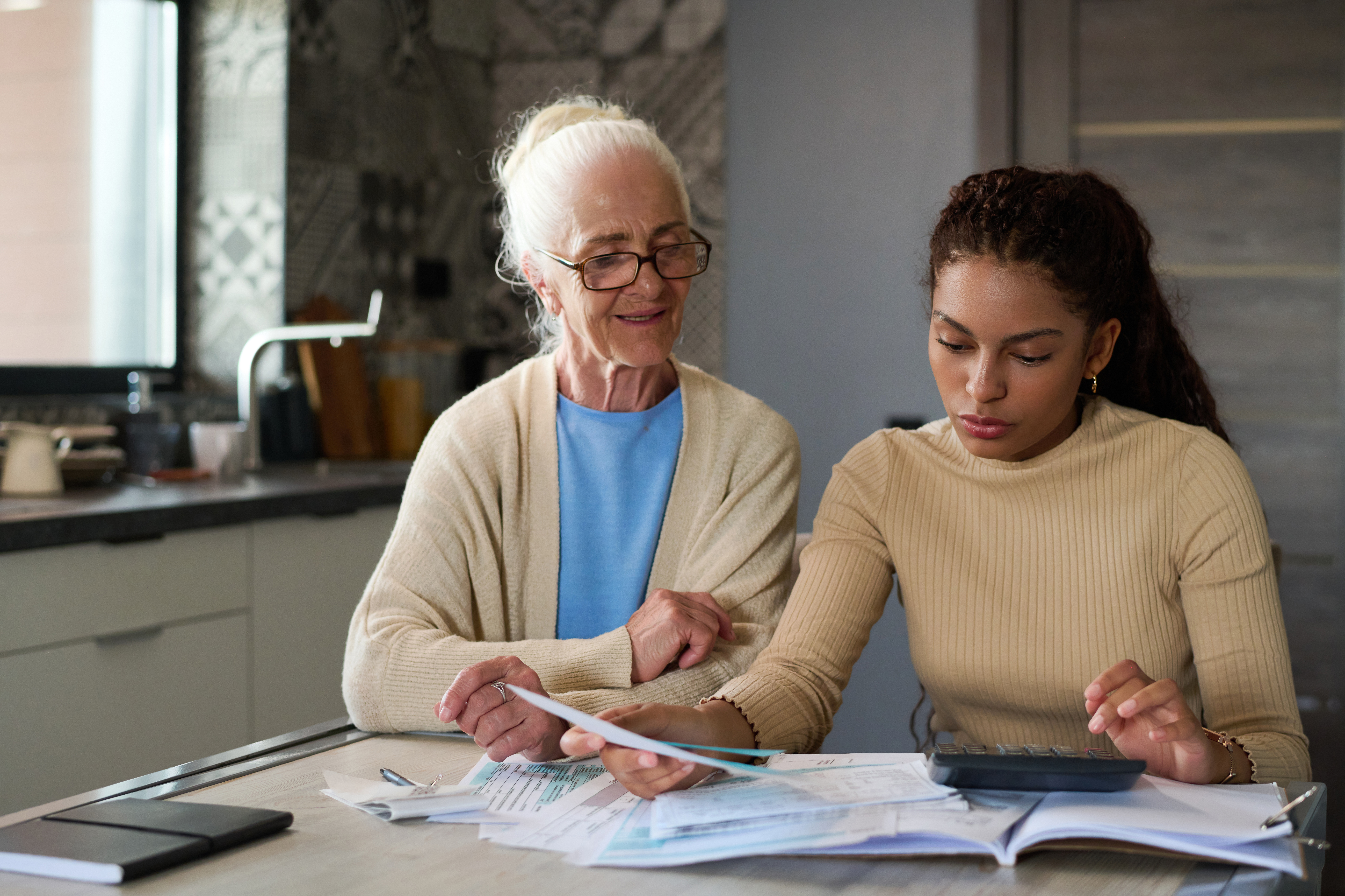 Multiethnic girl using calculator to count total sum of financial bill Multiethnic girl using calculator to count total sum of financial bill